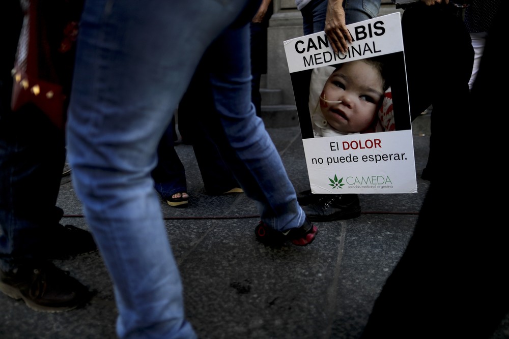 Mulher segura cartaz com mensagem a favor do uso terapêutico da cannabis nesta quarta-feira (29) do lado de fora do Senado da Argentina (Foto: AP Foto/Natacha Pisarenko)