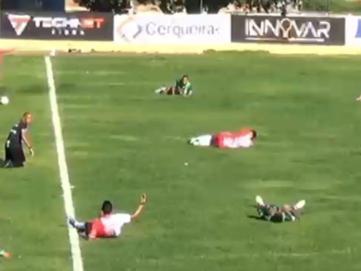 Jogadores deitam no chão após invasão de insetos durante partida de futebol no interior da Bahia